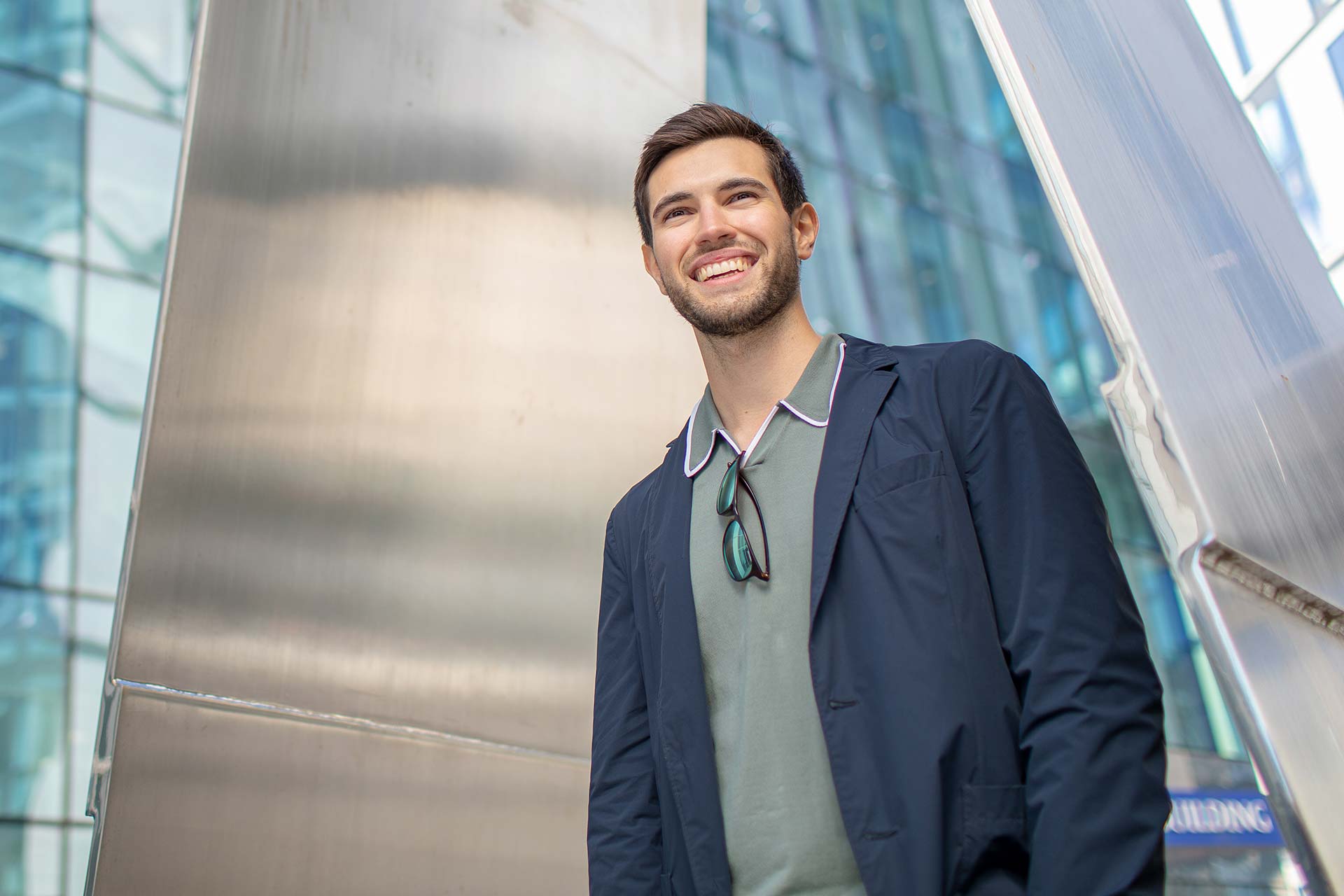 A PhD student walking past a building on campus