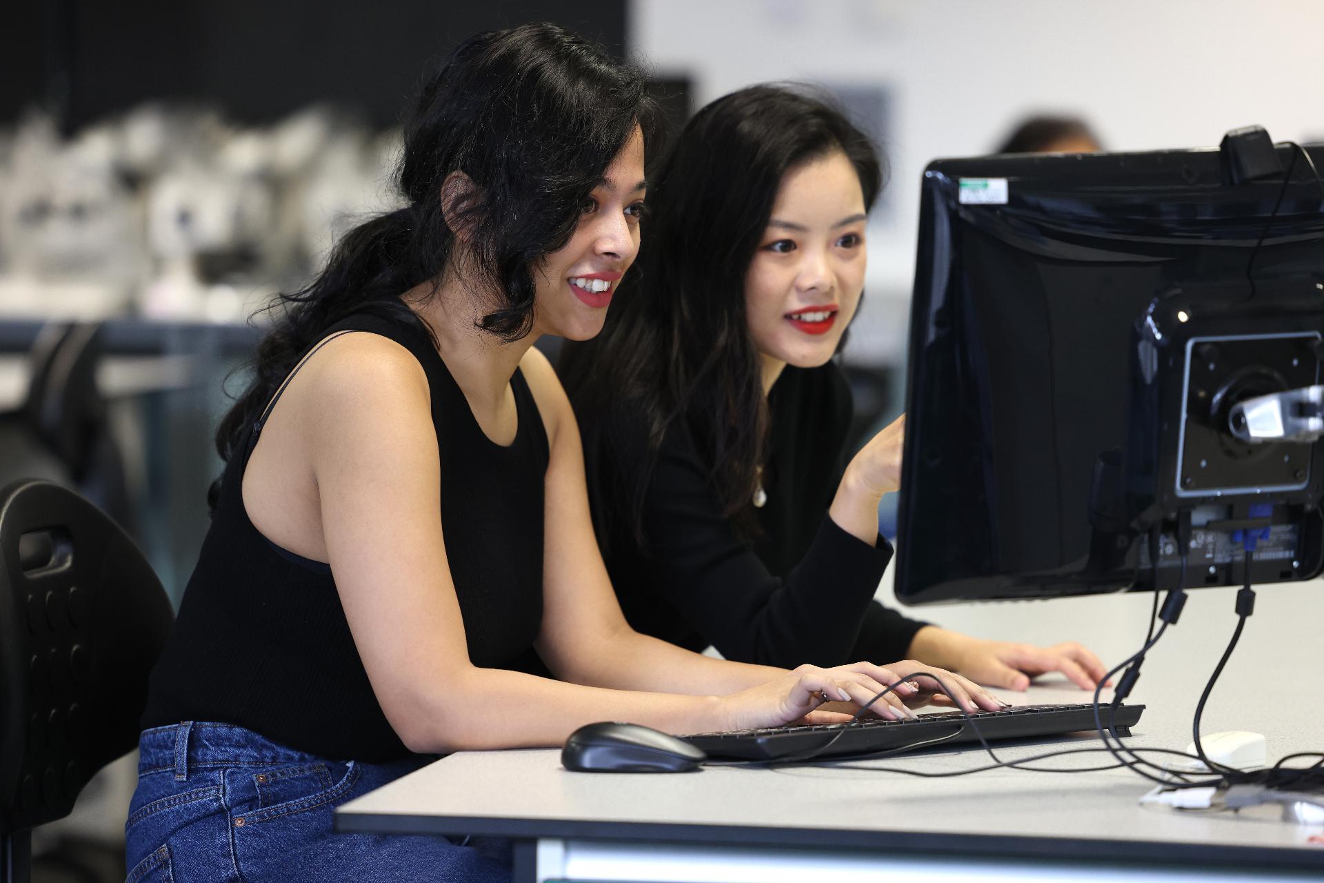 Ankita Mukherjee and Xueping Yang working on a computer