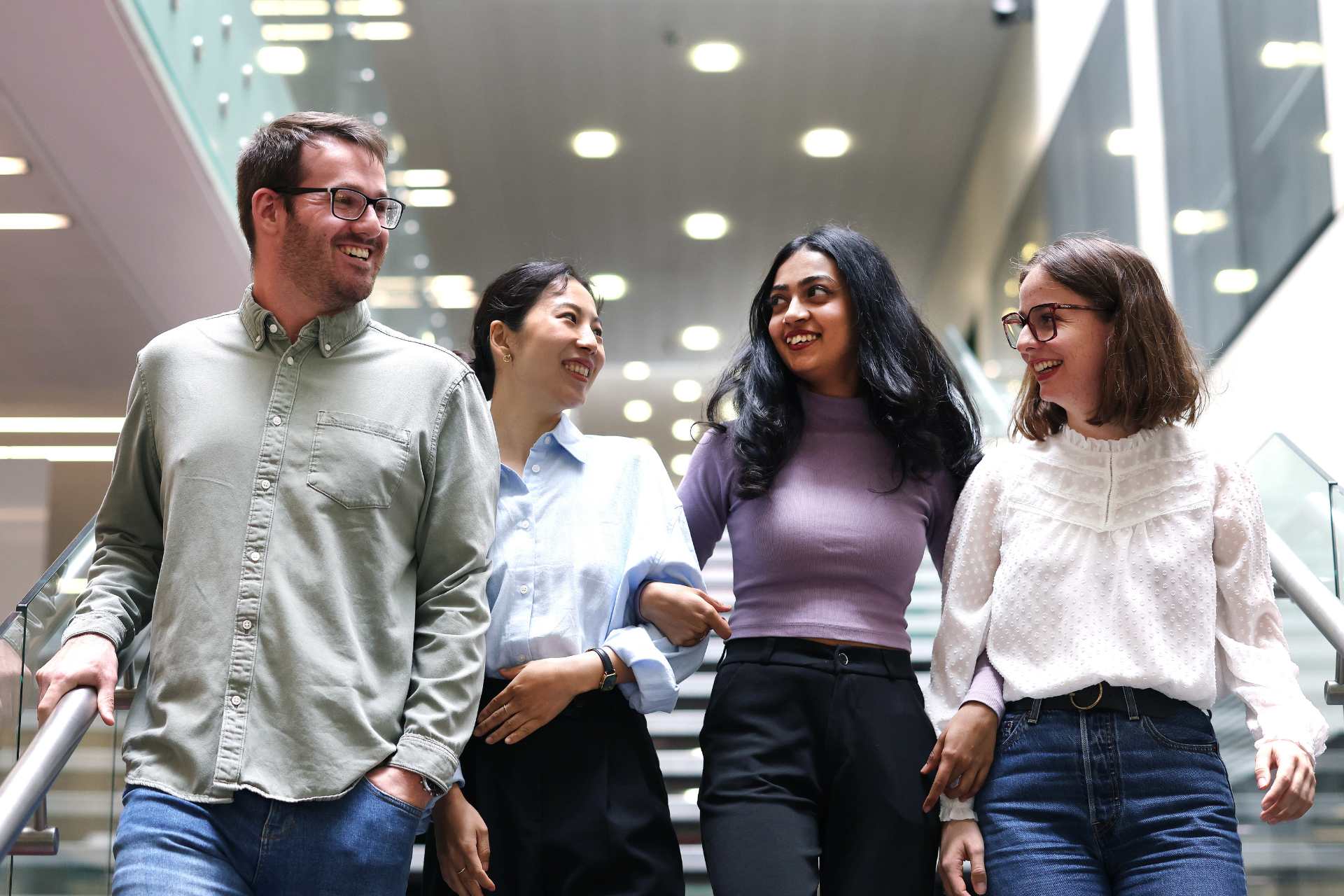 Four students walking down the stairs on campus