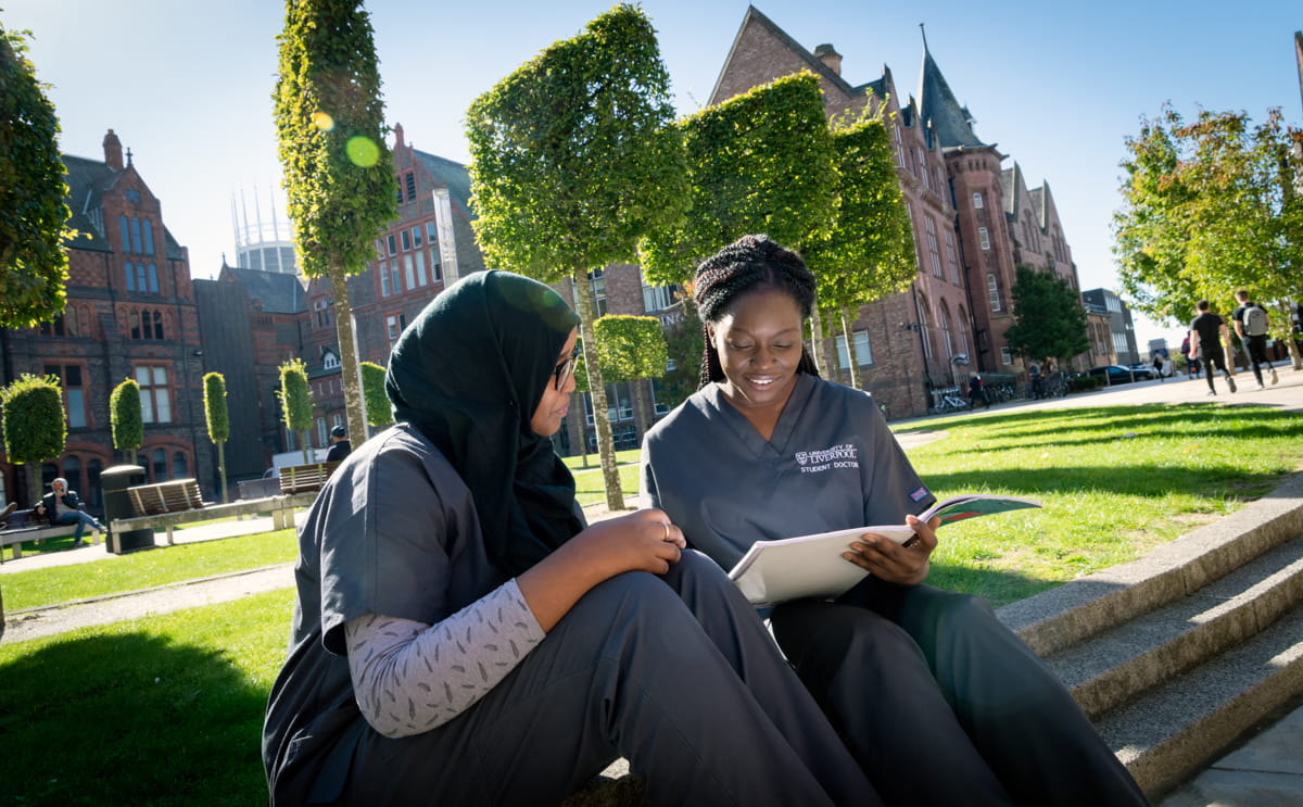 Two student doctors sitting outside