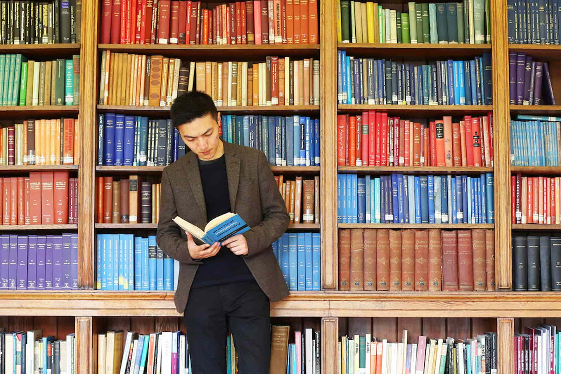 Student reading book in library