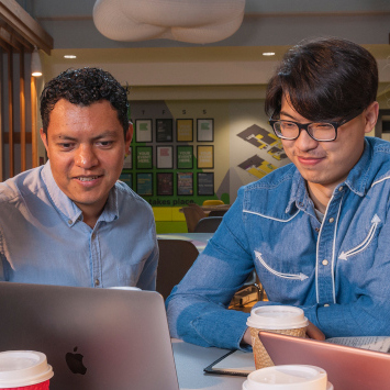 Two people looking at a laptop.