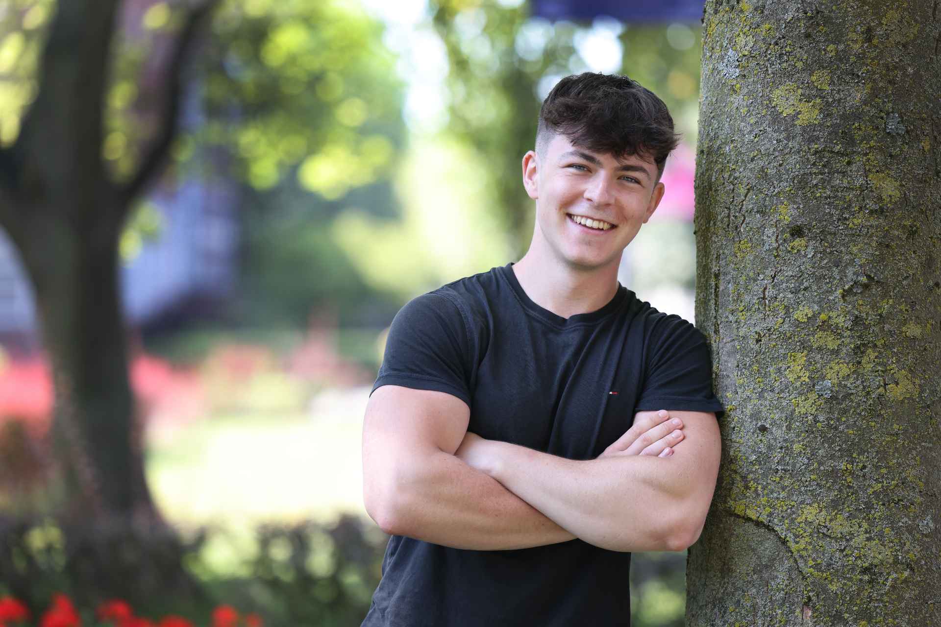 A student smiling outside on campus.