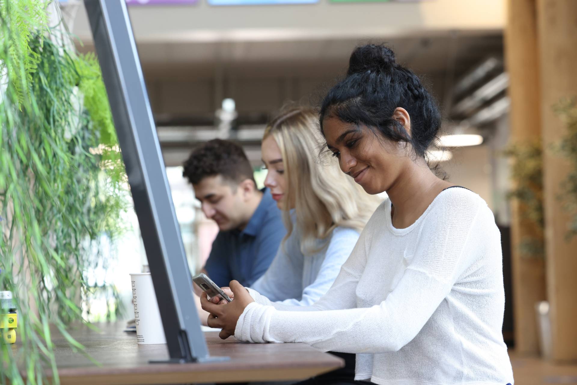 A student using their phone in a group study space.