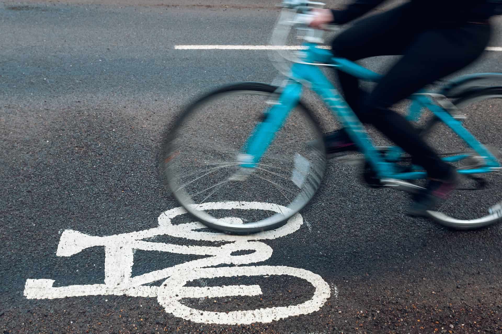 a blury bike speeding along a road where the bike lane symbol is clearly visible.