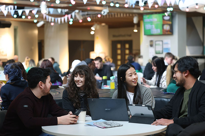 A group of students having a conversation around a table in the student union