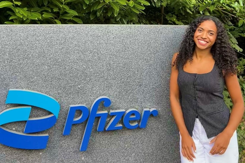 Charlotte Martin standing next to a Pfizer sign