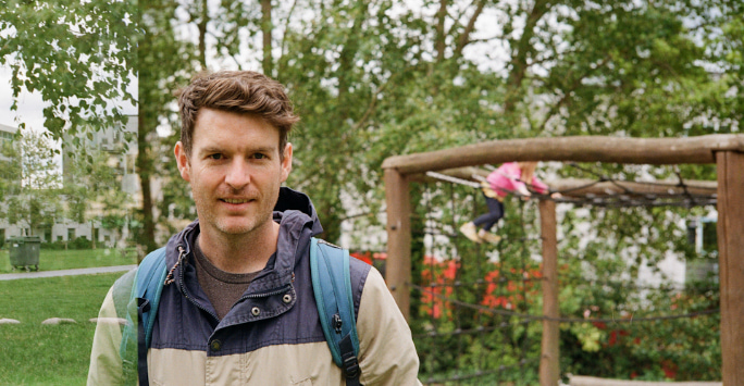 Colin Hammond in the park, children's climbing frame in the background