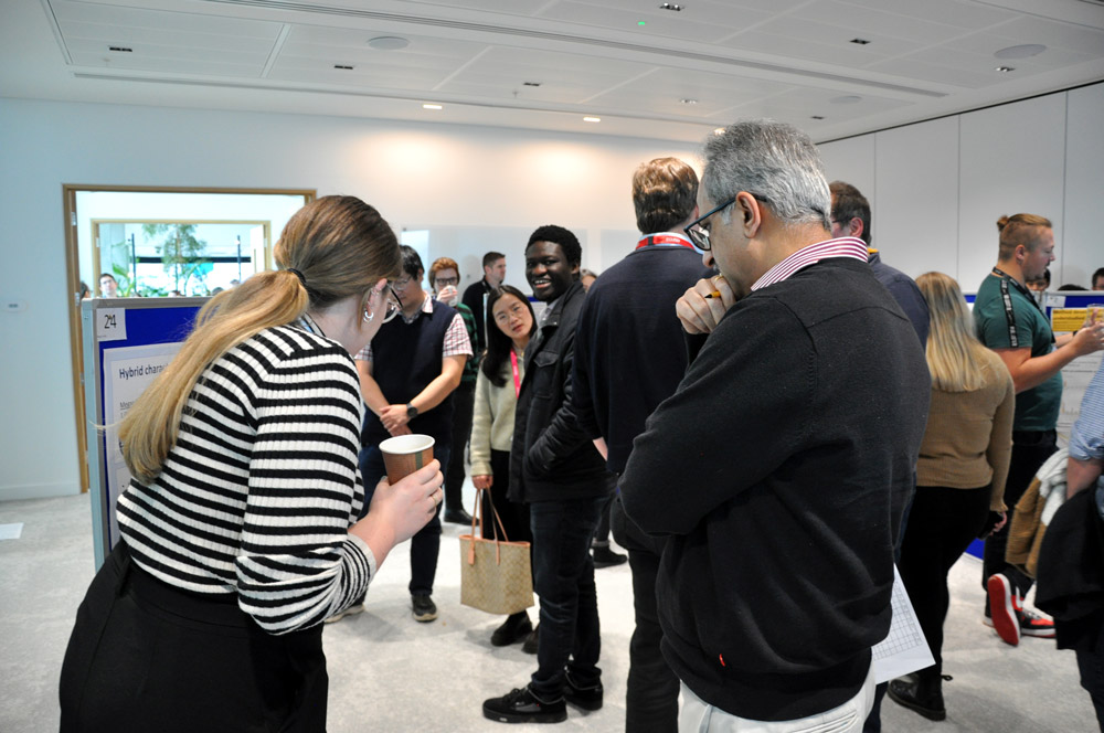 People gathering around to view and discuss poster presentations