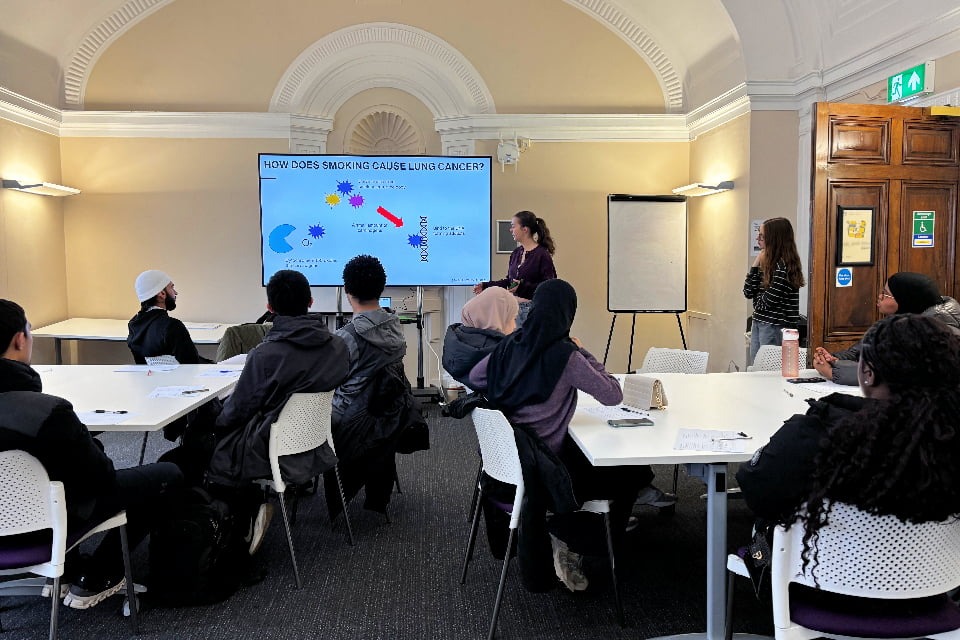 Undergraduate student explaining research to young people