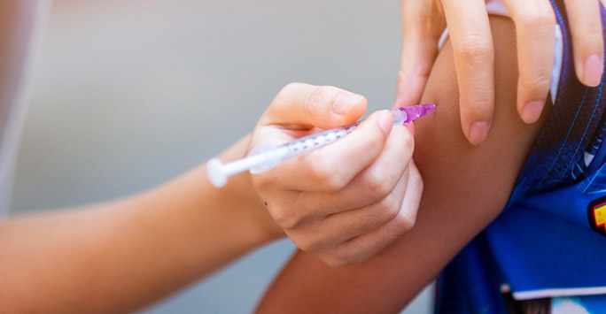 Child receiving vaccine from a nurse