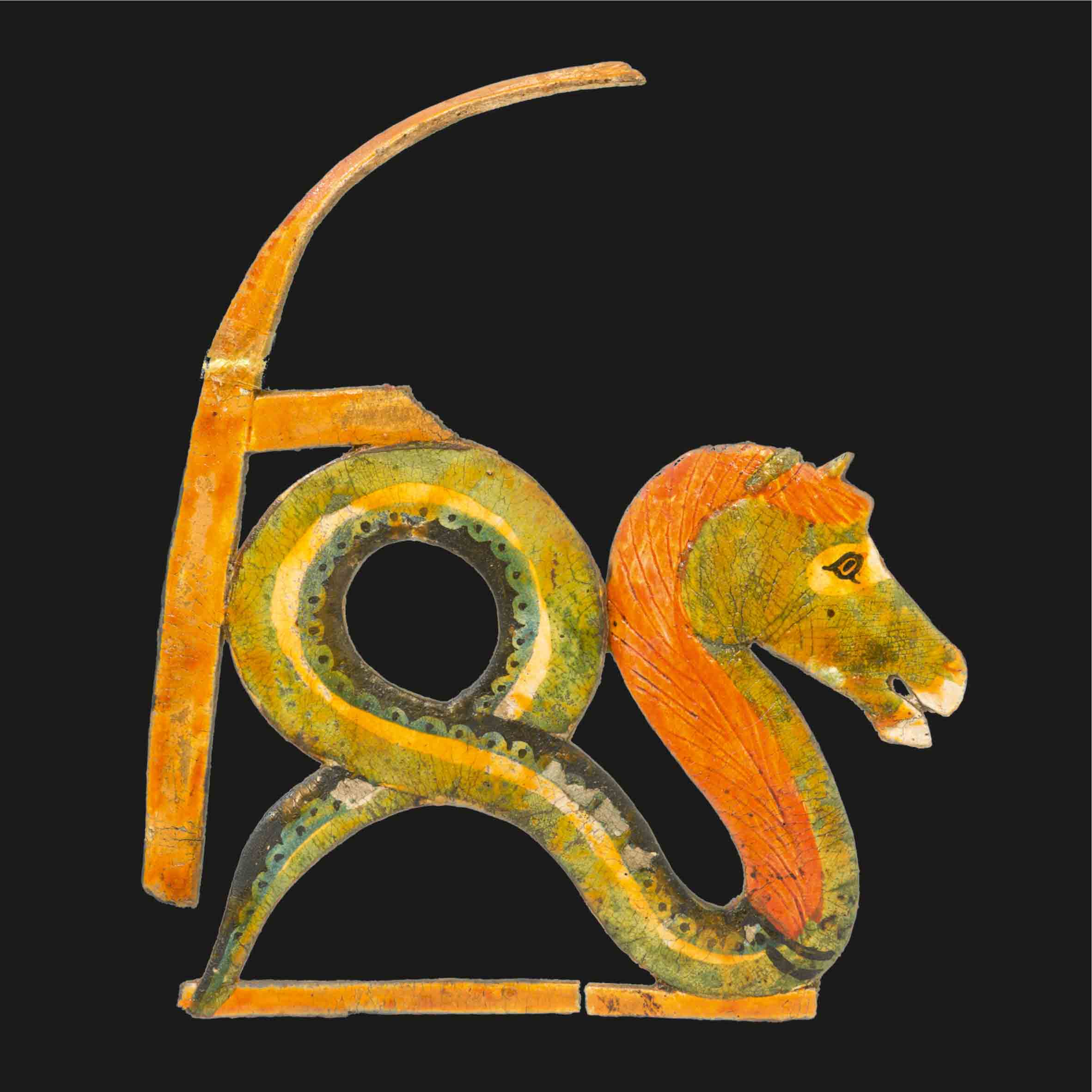 Colourful artefact in the form of a creature with the head of a horse and the body of a snake