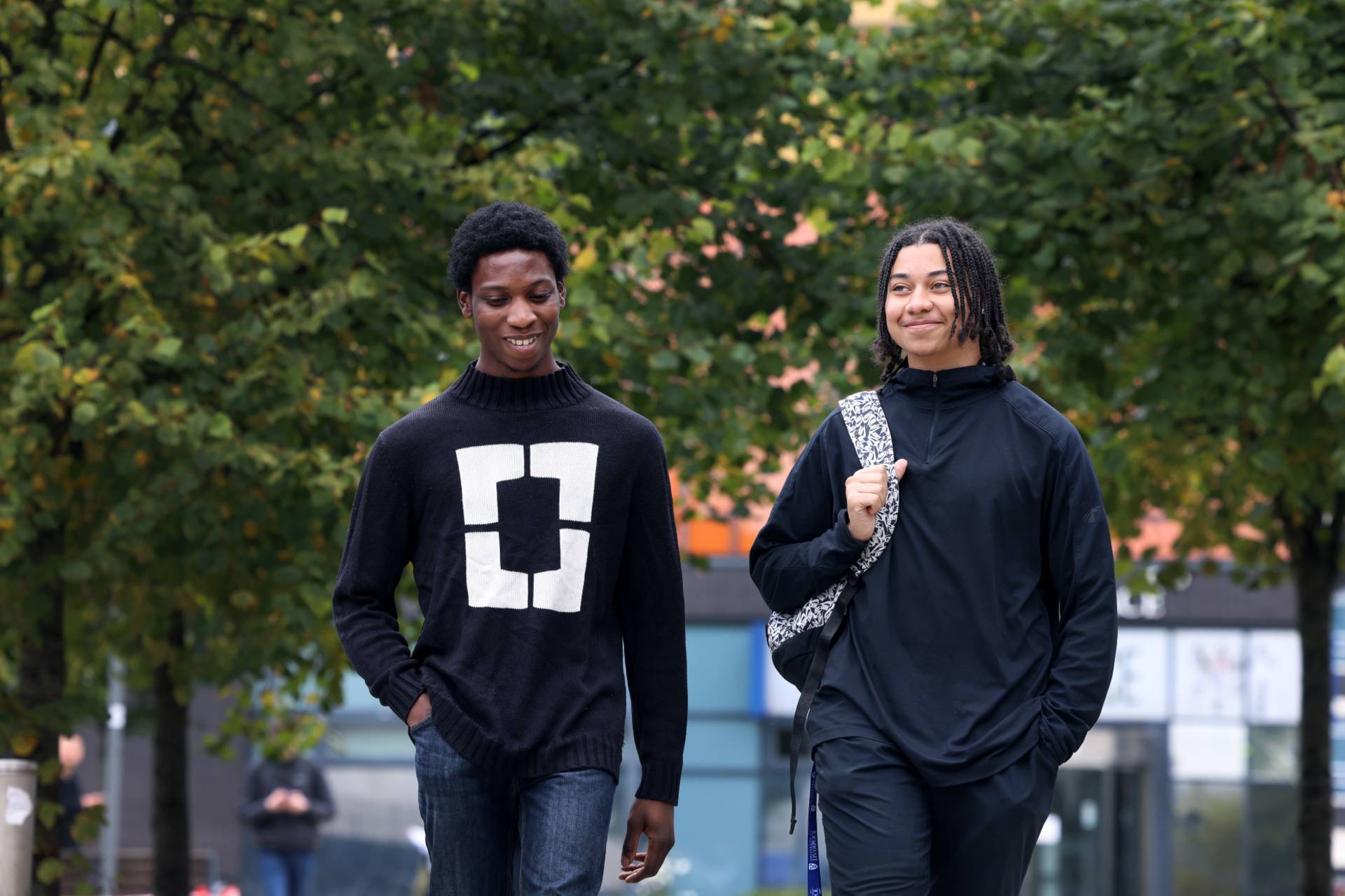 Two students walking across campus together