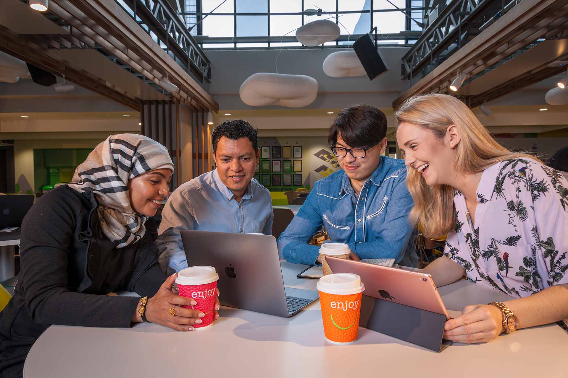 Four students chat over a coffee.