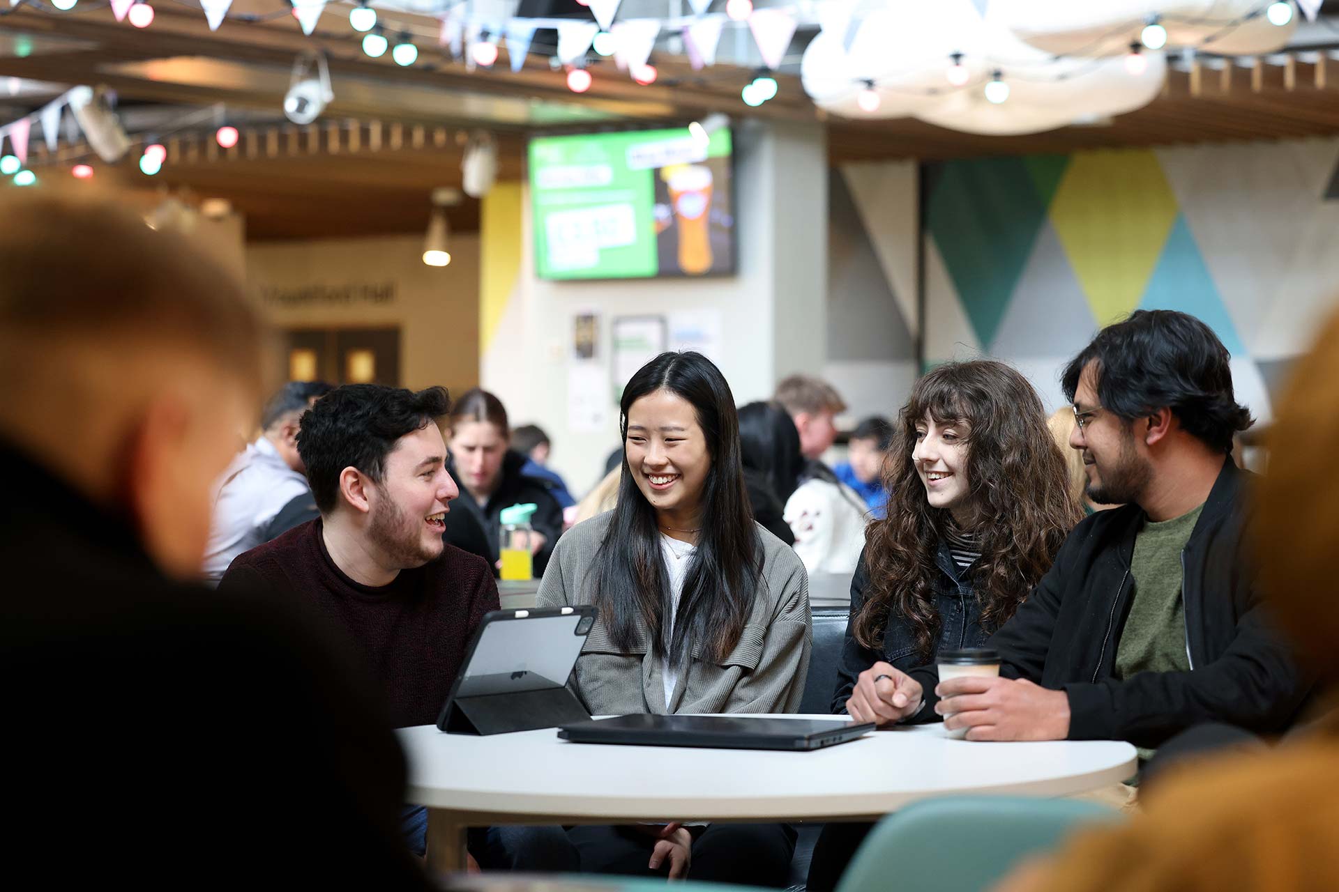 Students chatting while sat round a table in the Guild.