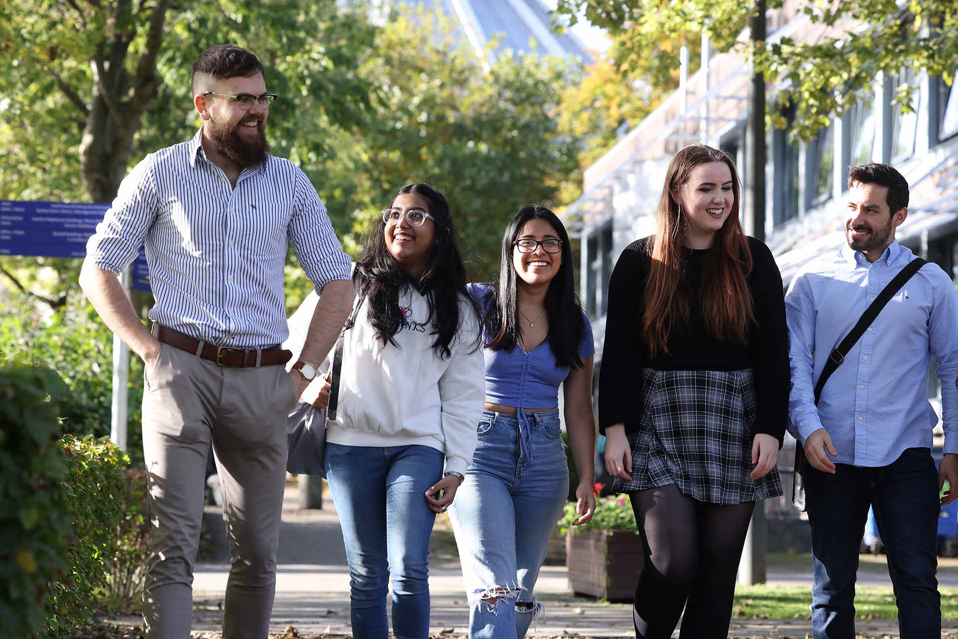 Five students walking on campus.