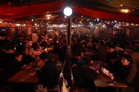 2+2 students at a festive celebration in a tent at the Christmas markets
