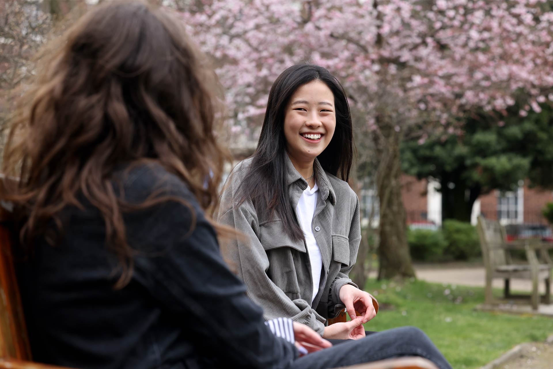 A Chinese student and a friend sitting on a bench in Abercromby Square