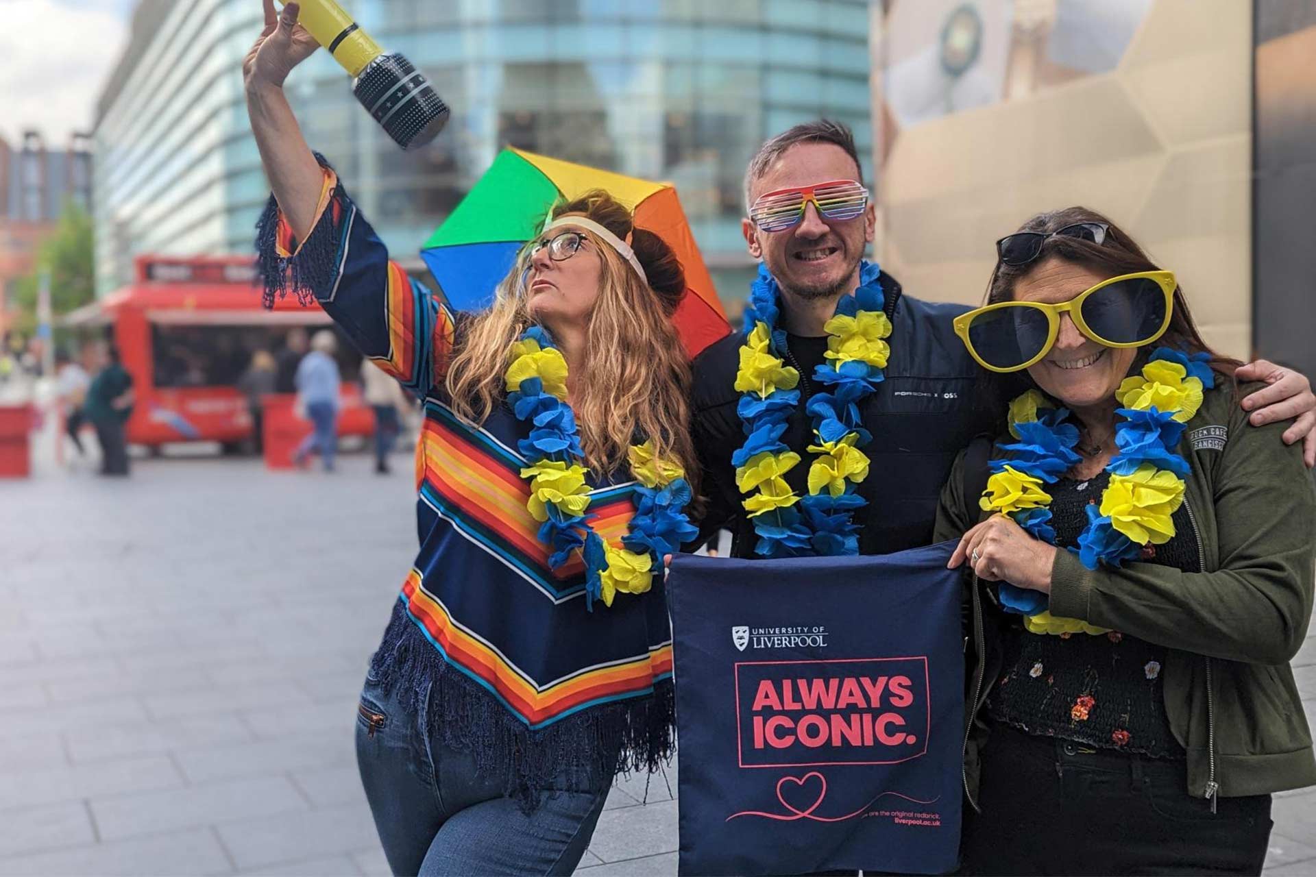 Three people in Liverpool One celebrating Eurovision