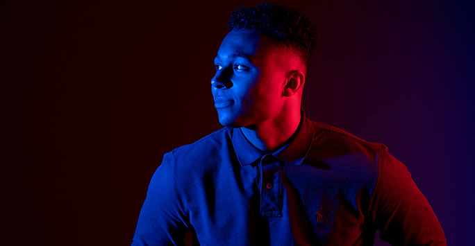 Colourful photograph portrait of a student against a dark background