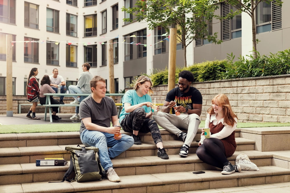 A group of students sitting on external stairs