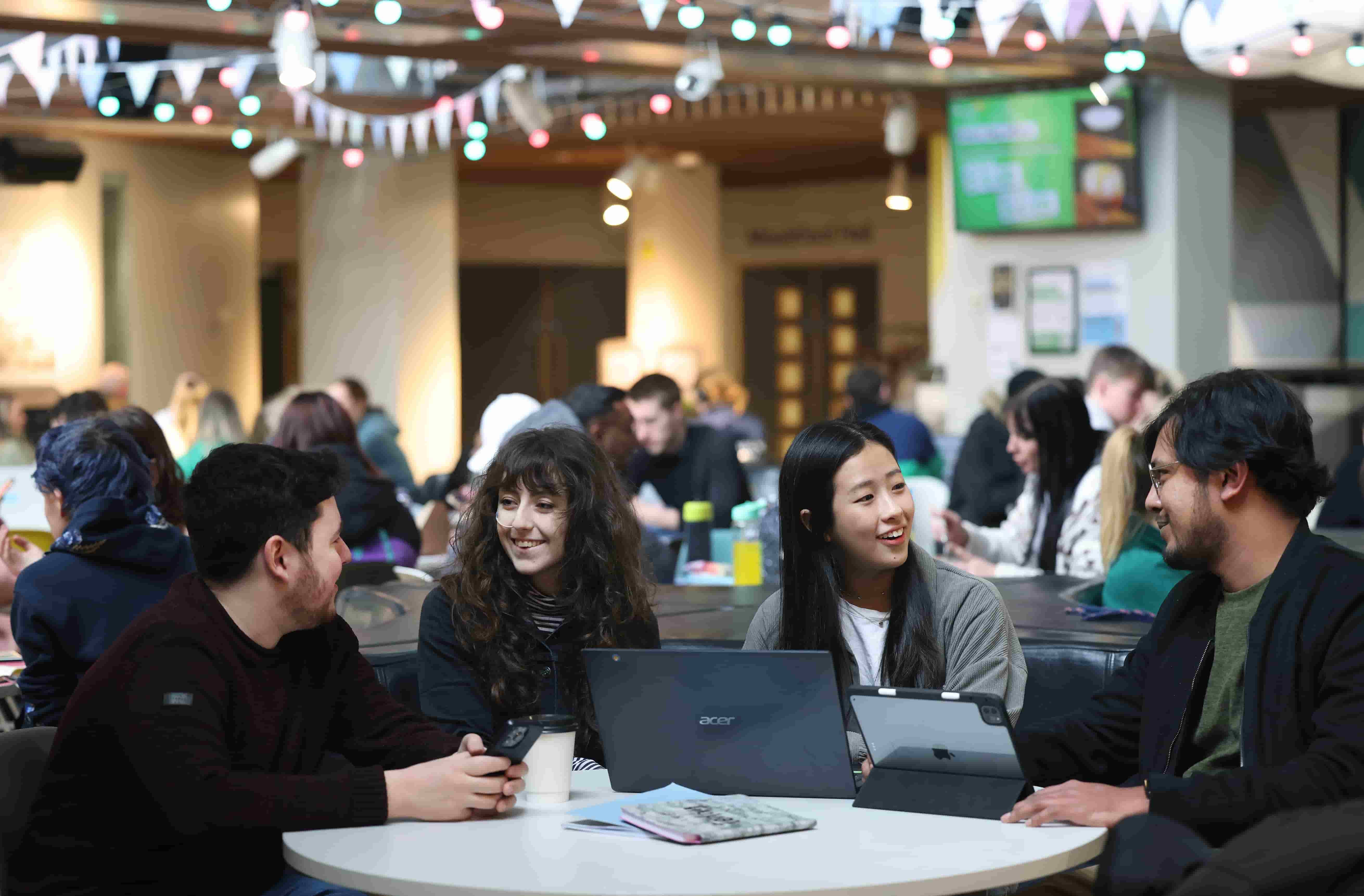 A group of students talking around a table in the Guild of Students