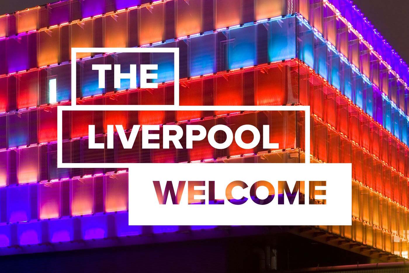 The Liverpool Welcome podcast logo with a building illuminated in multiple colours in the background.