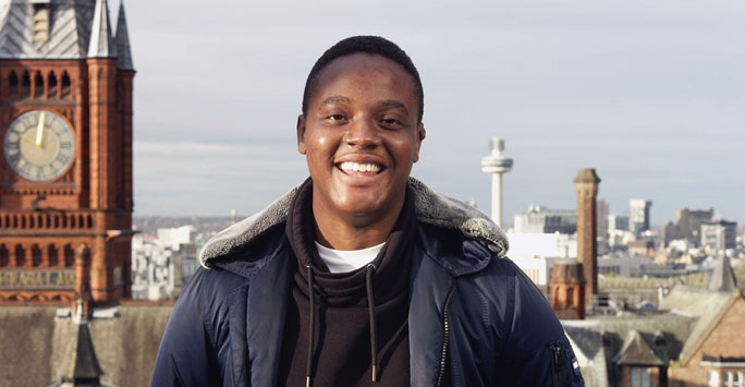 Student smiling infront of the City of Liverpool