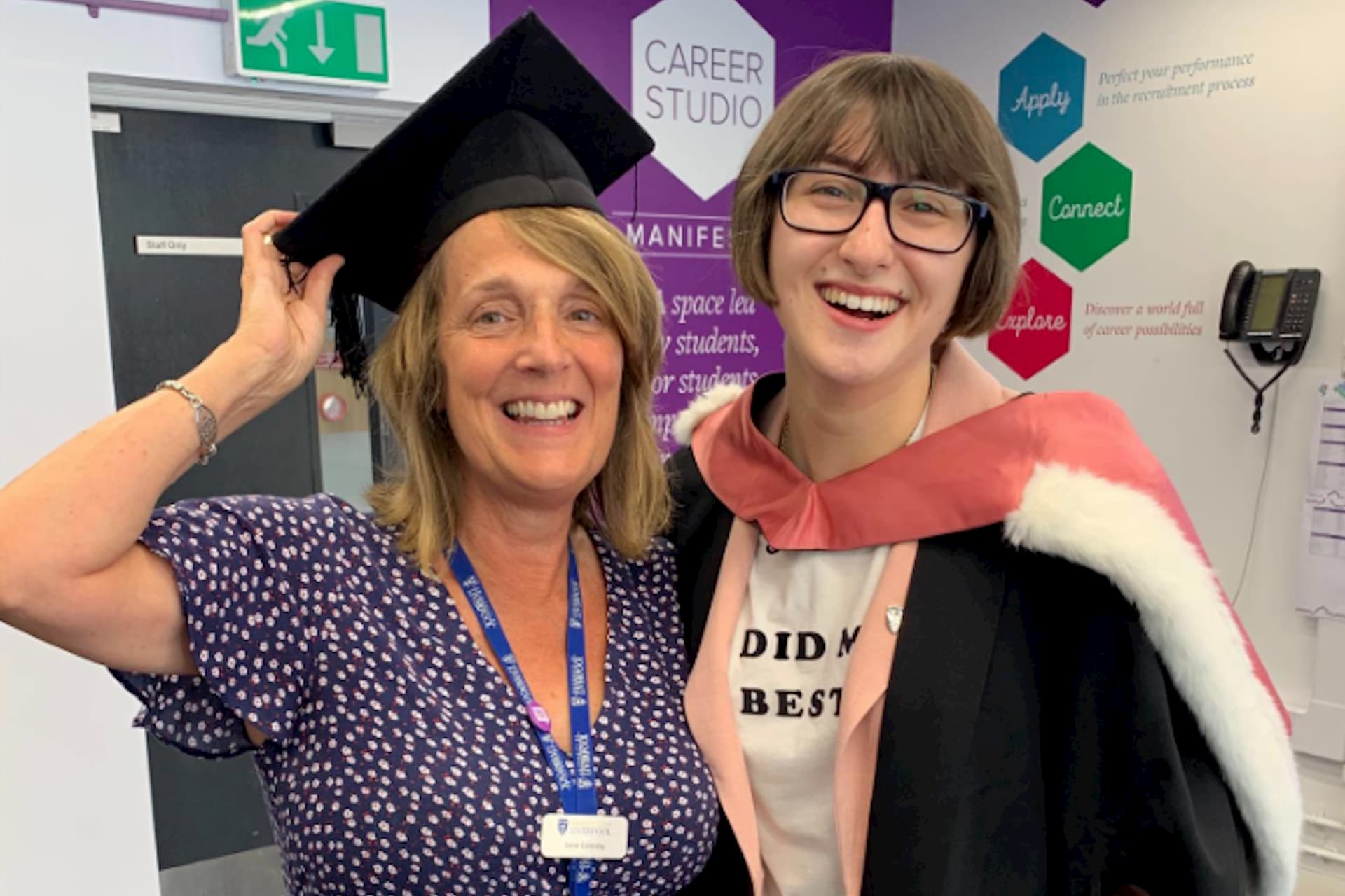 Student celebrating at graduation with careers staff member