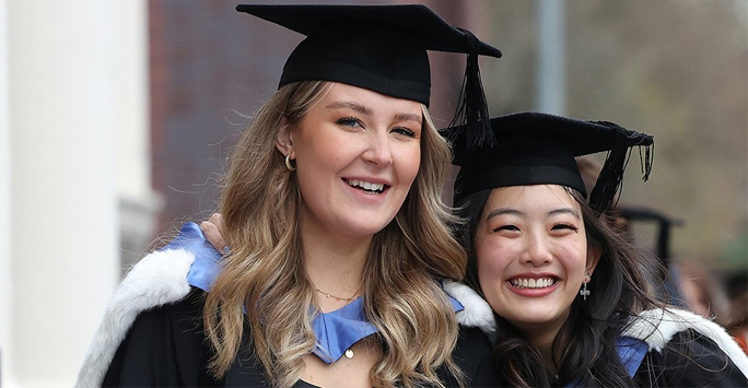 Two graduates in their academic dress on graduation day