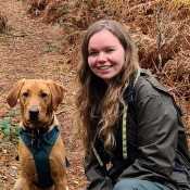 Christina and her dog posing for a photo in a forest