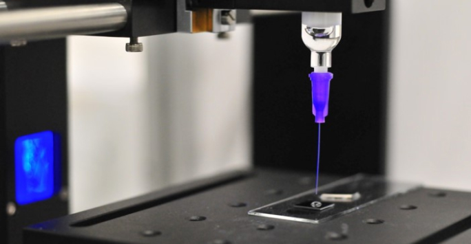 A 3D printer in operation, producing a vibrant blue liquid as part of the printing process.