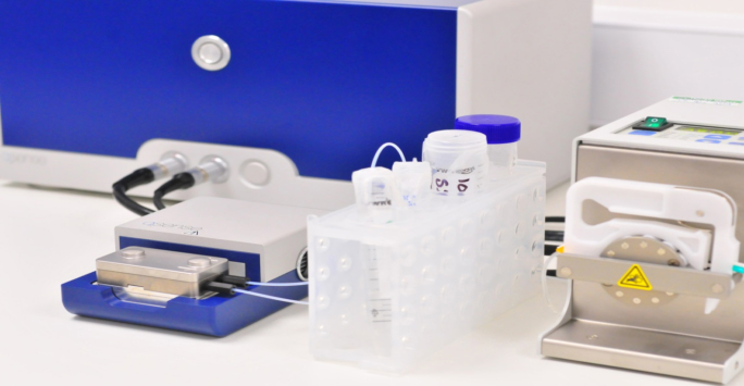 A laboratory featuring a blue and white machine, surrounded by scientific equipment and research materials.