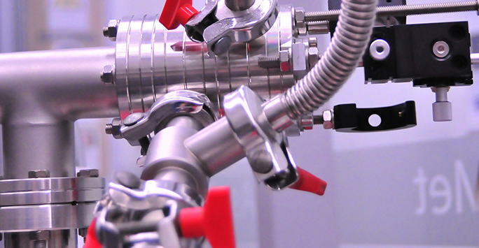 Close-up view of a metal pipe featuring red handles, highlighting its industrial design and functionality.