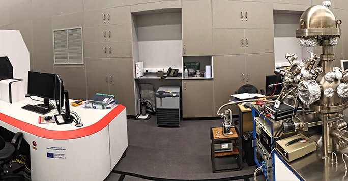 A spacious room featuring a desk with a computer, showcasing a professional and organized workspace.