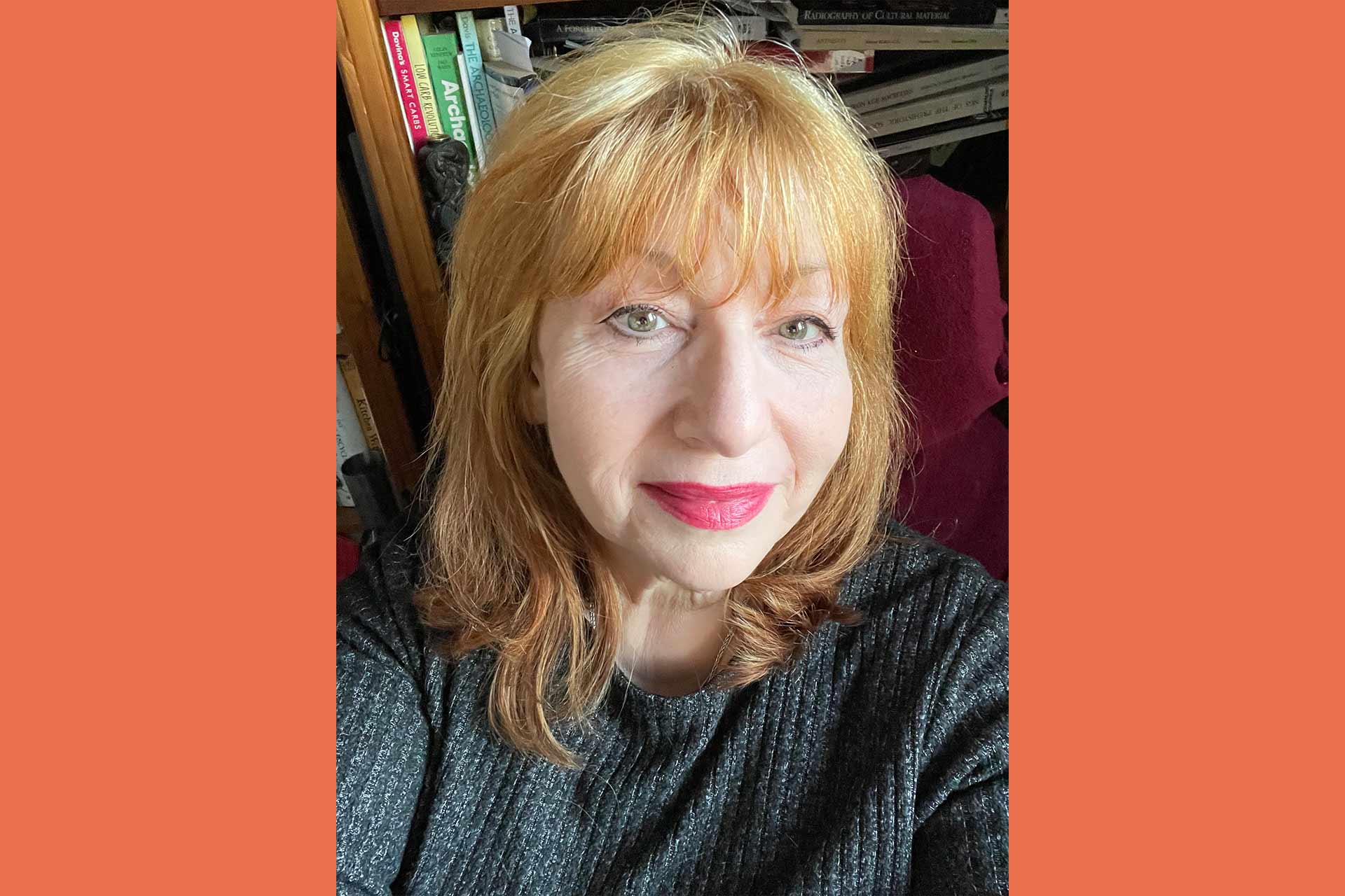 Vivien is a woman with light coloured red hair, smiling at the camera