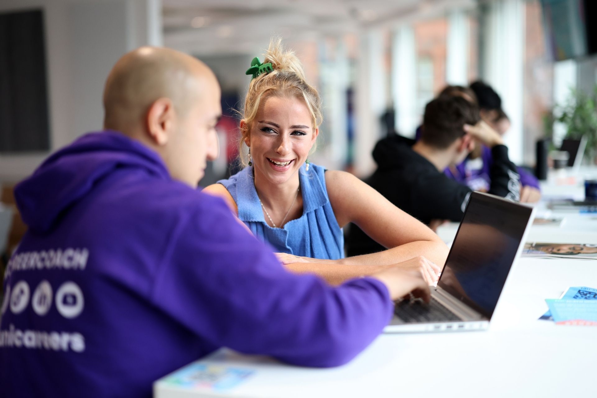 A University of Liverpool career coach providing guidance to a student in a bright study space, discussing career opportunities.