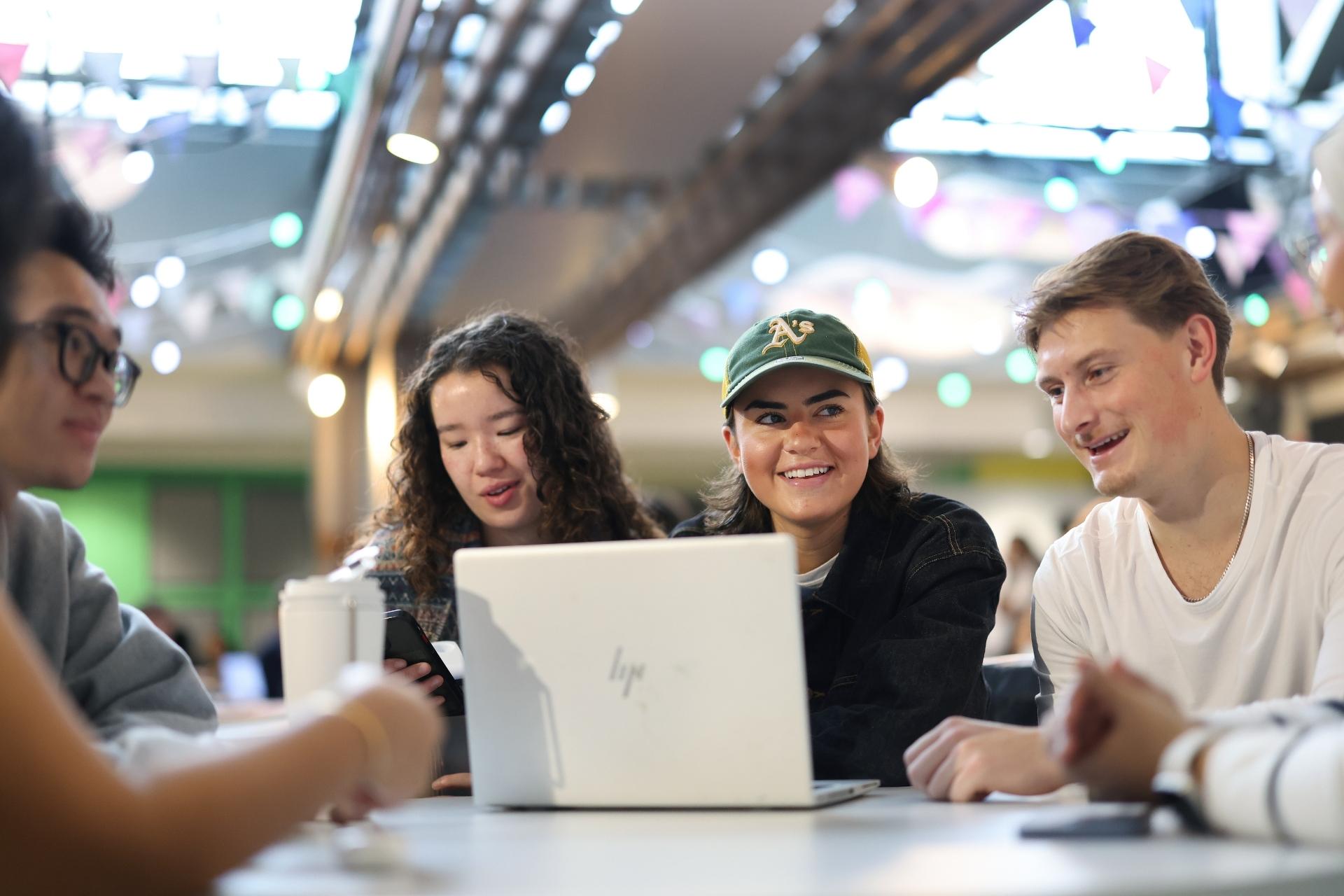 A group of University of Liverpool students collaborating in a dynamic study space, discussing career options and future opportunities.
