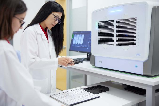 Two scientists are working on a computer in a lab