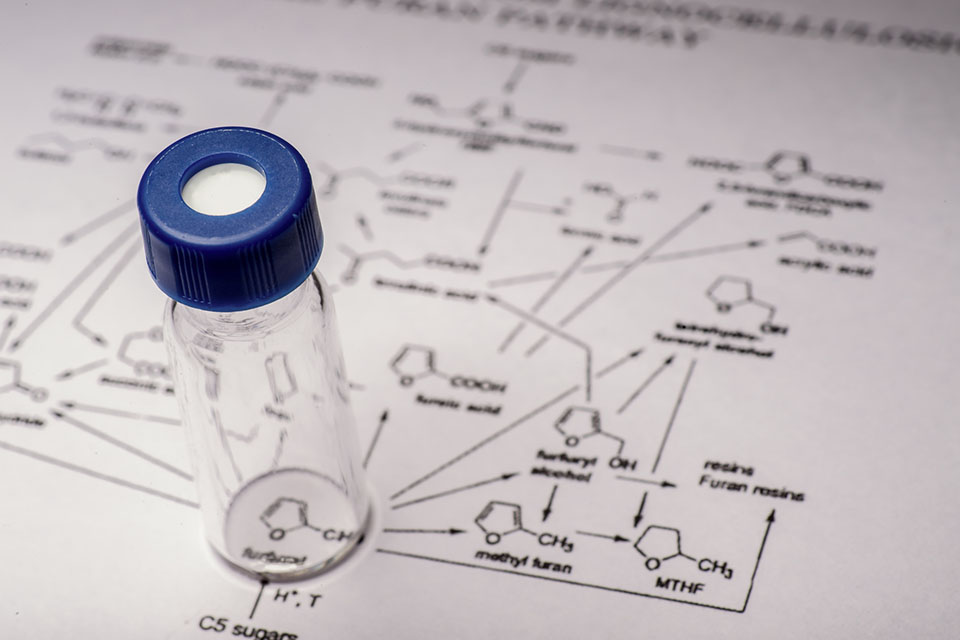Small liquid vial on a piece of paper with molecule drawings