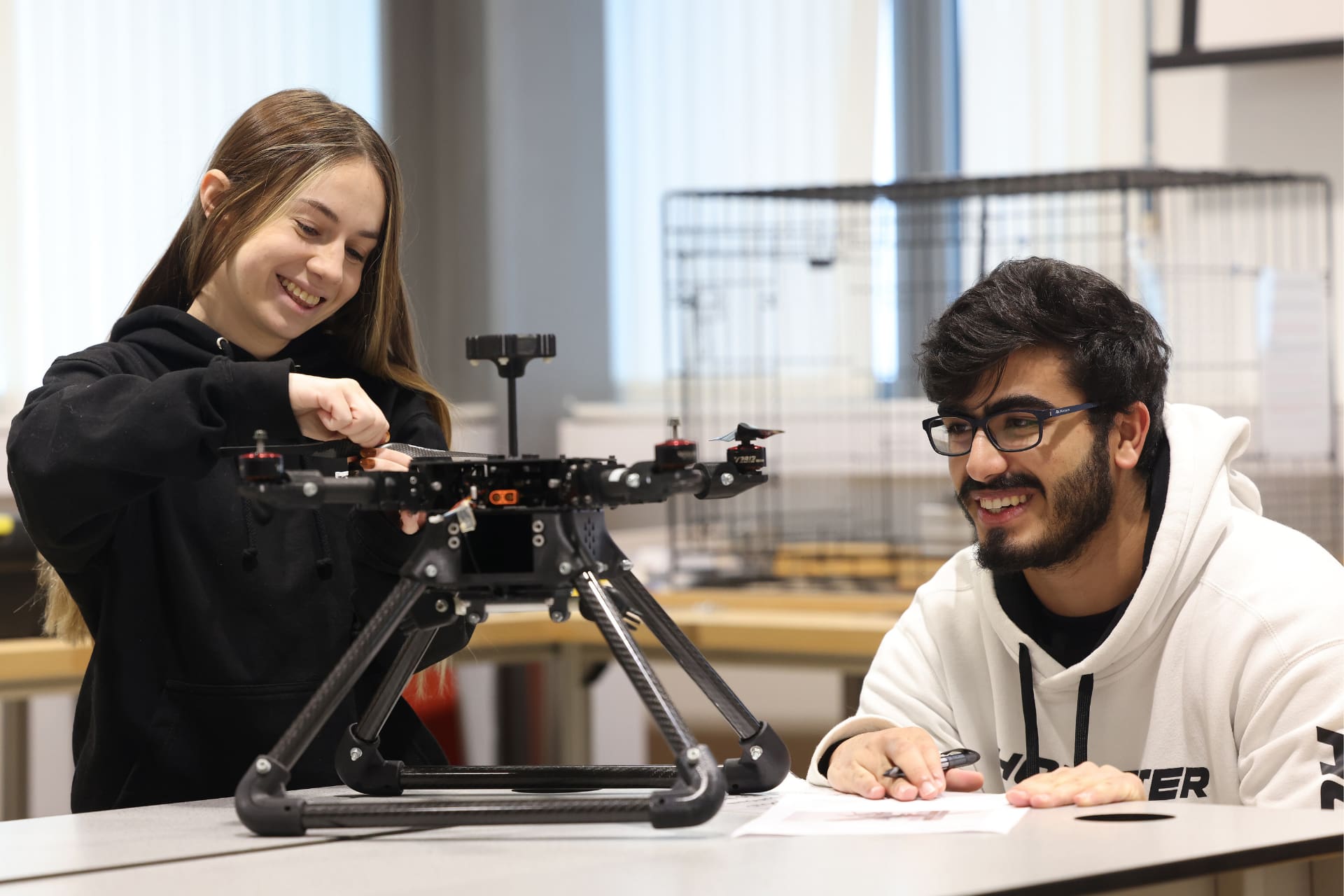 Two engineering students working on a drone.