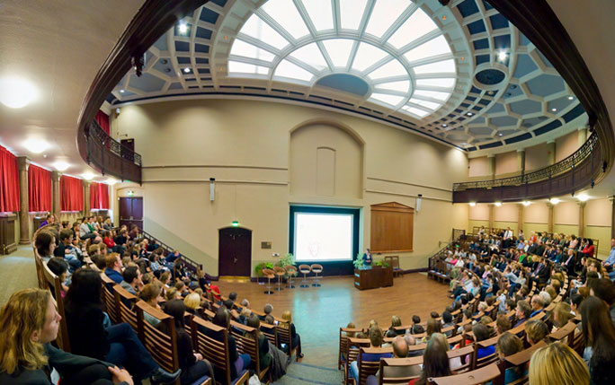 A room with people seated on chairs