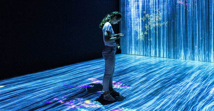 A woman standing against a digital projection