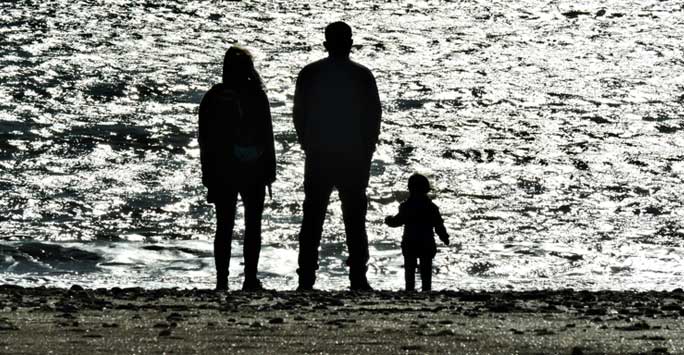 Silhouette of a family standing on a beach