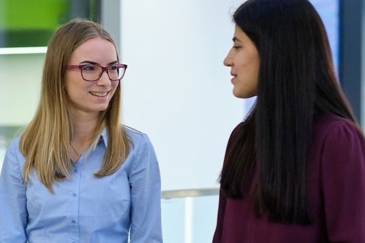 Two students have a discussion in the Management School