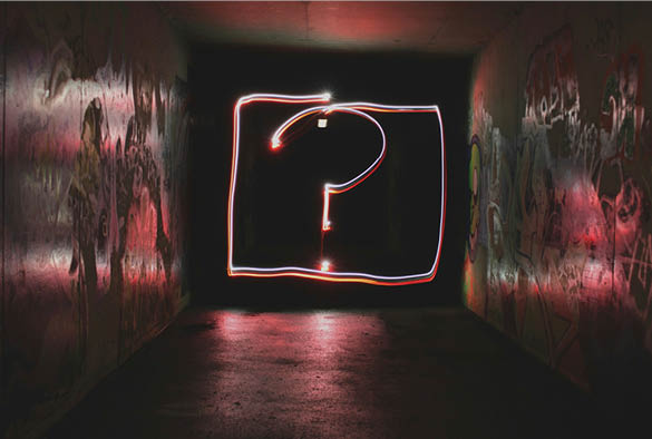 A black corridor with a neon sign at the bottom with a large \'?\'.