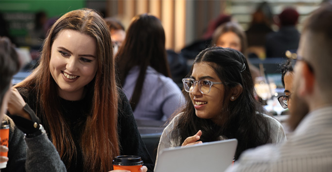 A group of students huddled around a table together.