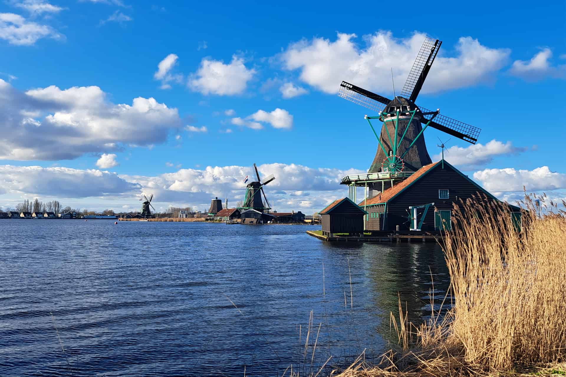 Windmills on a canal on a sunny day.