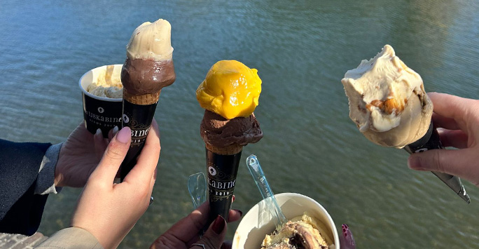 The hands of the five students each holiding an icecream.
