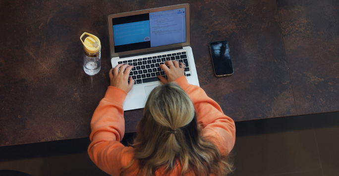 Student at desk using laptop.